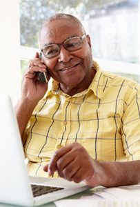 Man in a yellow shirt having a phone conversation