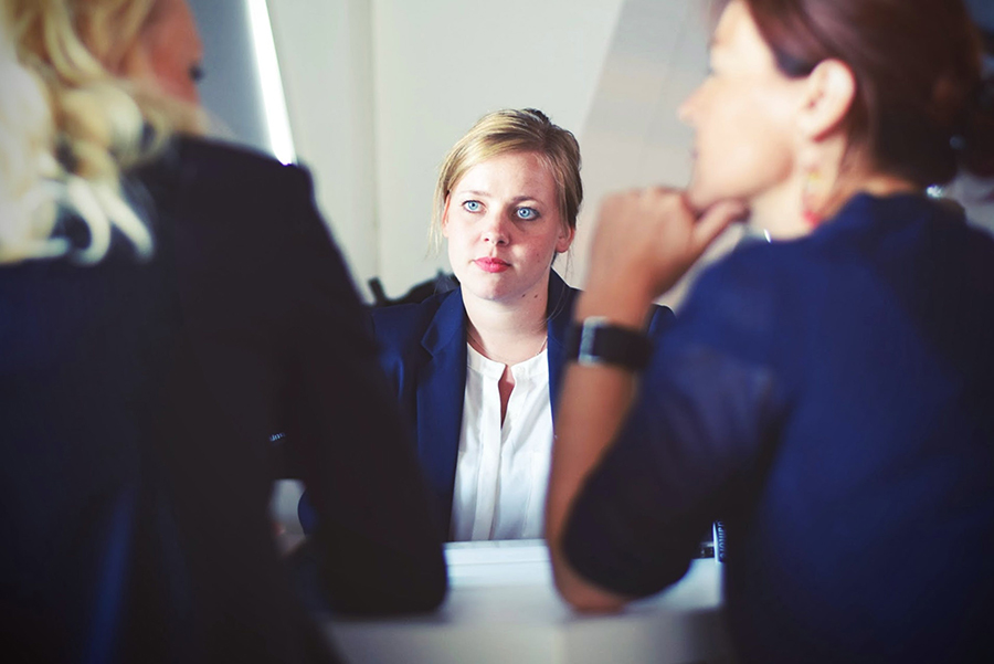 Woman listining to two colleagues all wearing blue