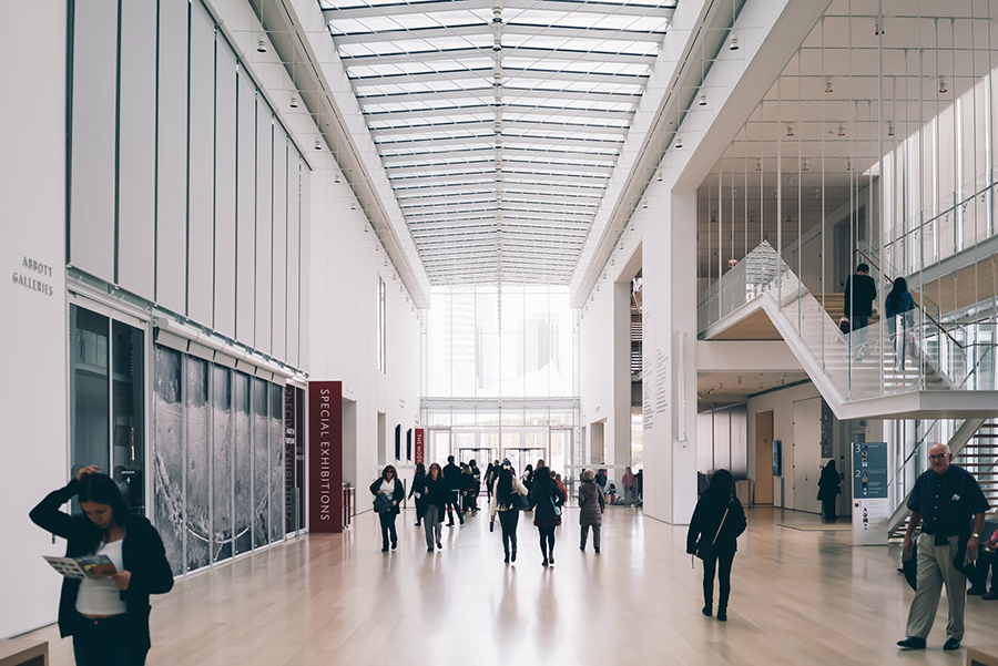 The lobby of an office building with people walking and reading papers