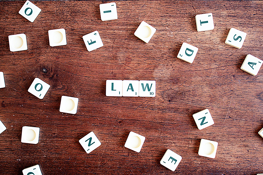 Plastic blocks on a wooden table that spell out LAW