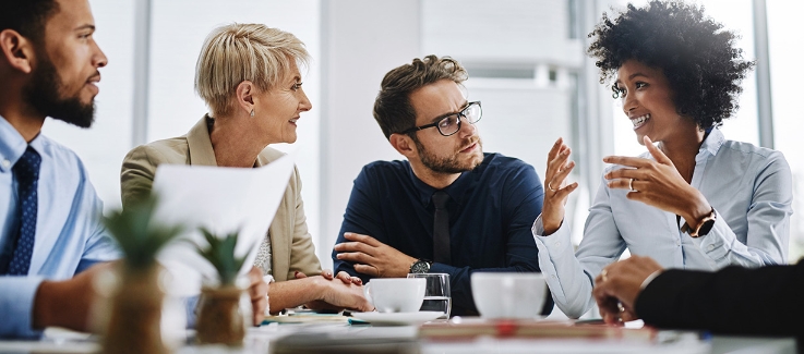 Colleagues having a discussion in a meeting over coffee