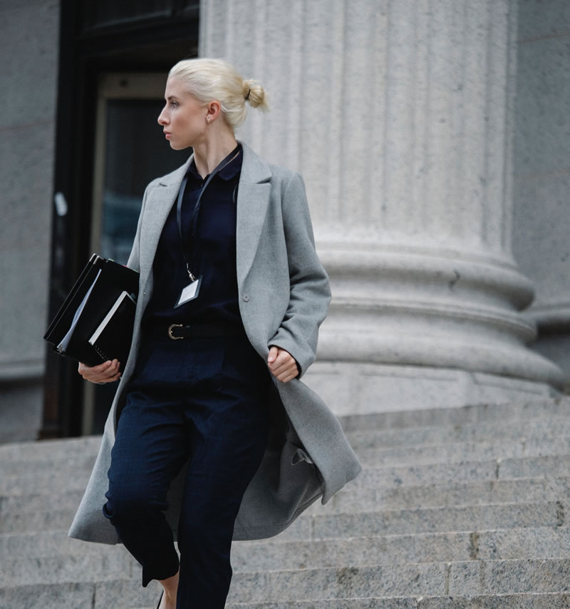 Woman running down steps of a courthouse