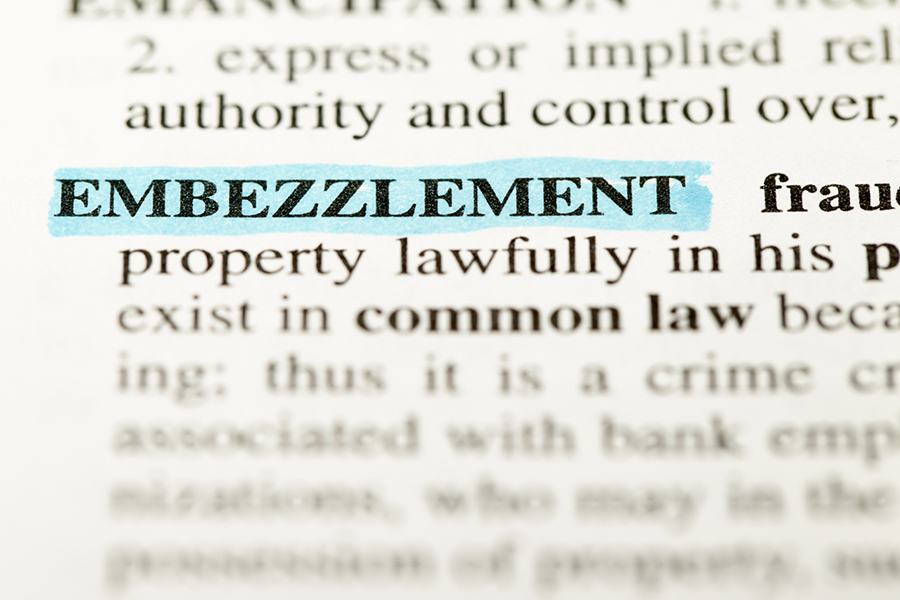 The word EMBEZZLEMENT highlighted on a piece of paper