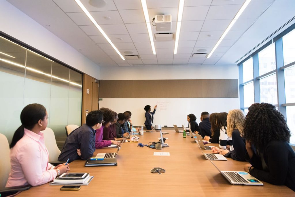 Woman giving a presentation on a whiteboard in a meeting