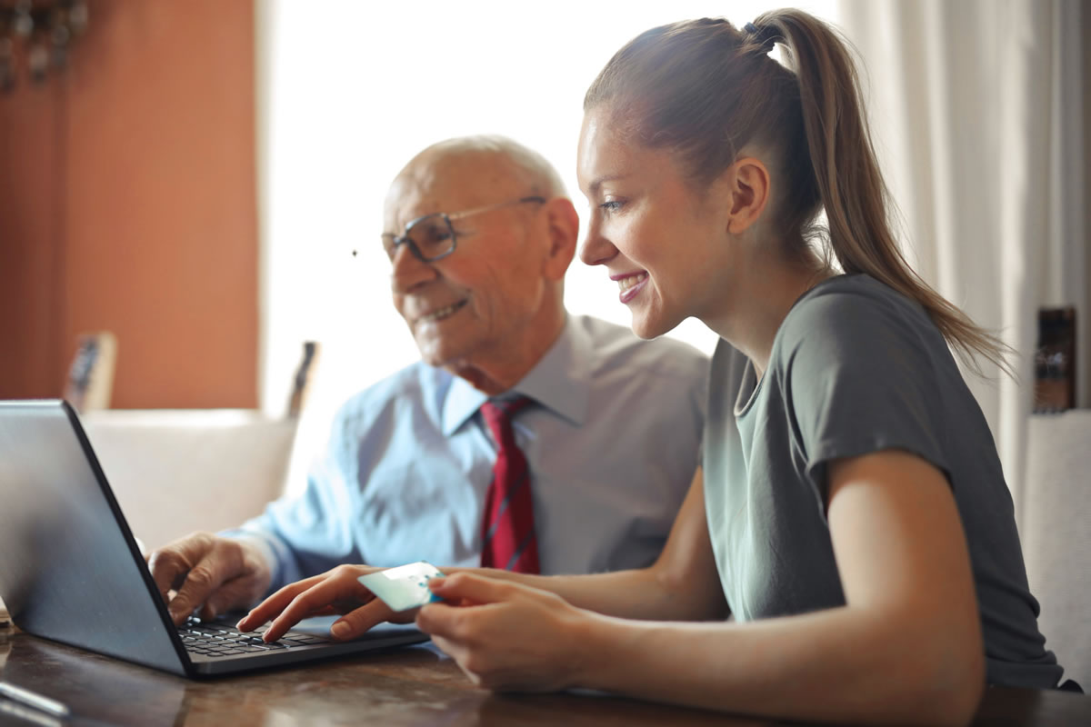 Man and woman using a credit card on a laptop