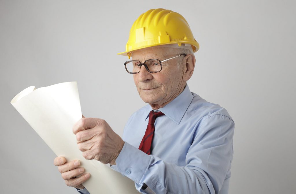 Man in a hardhat looking at blueprints