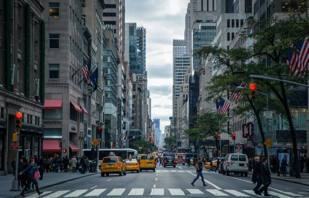 A New York block with a crosswalk and yellow cabs