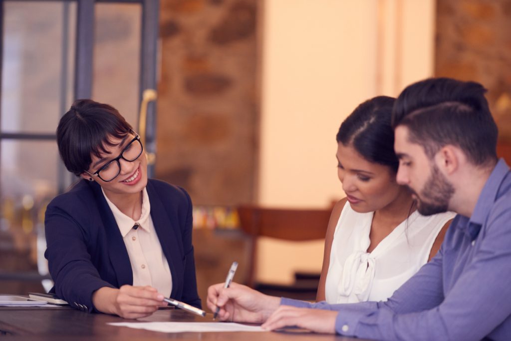 Colleagues discussing notes on a piece of paper while holding pens