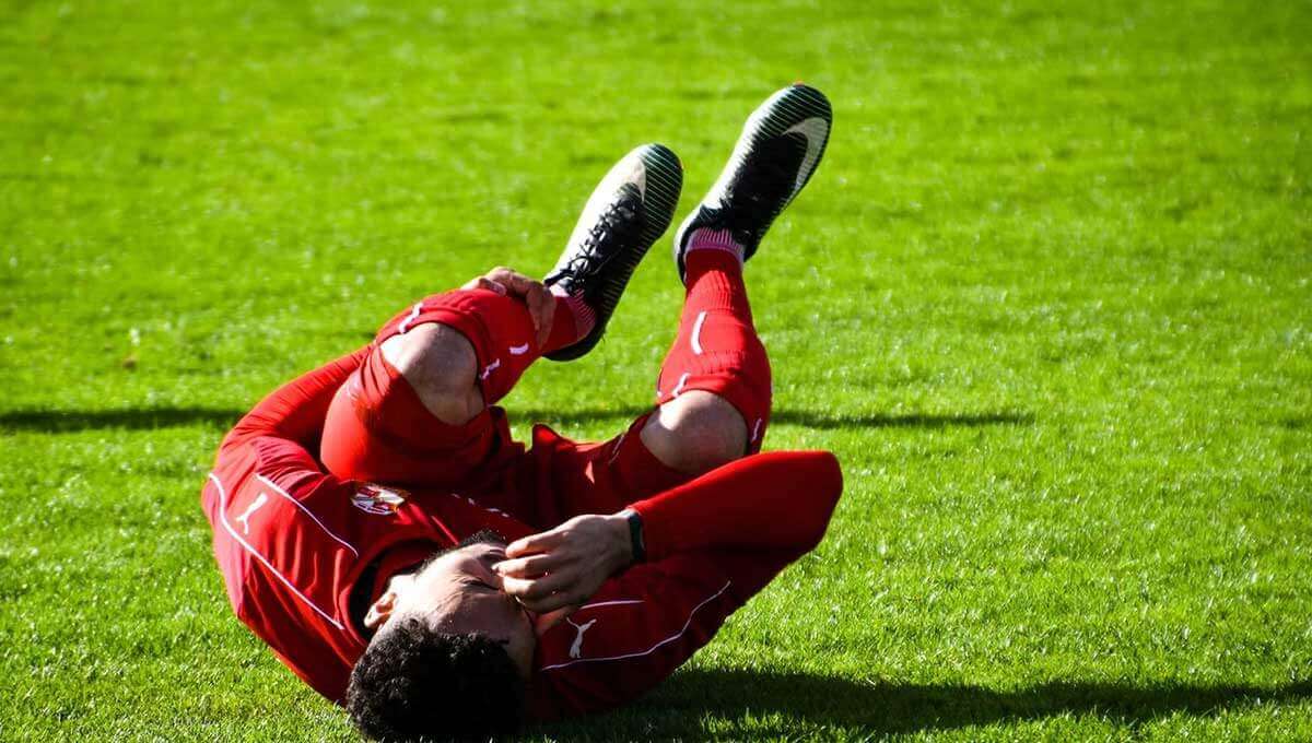 Soccer player hurt on a field of green grass