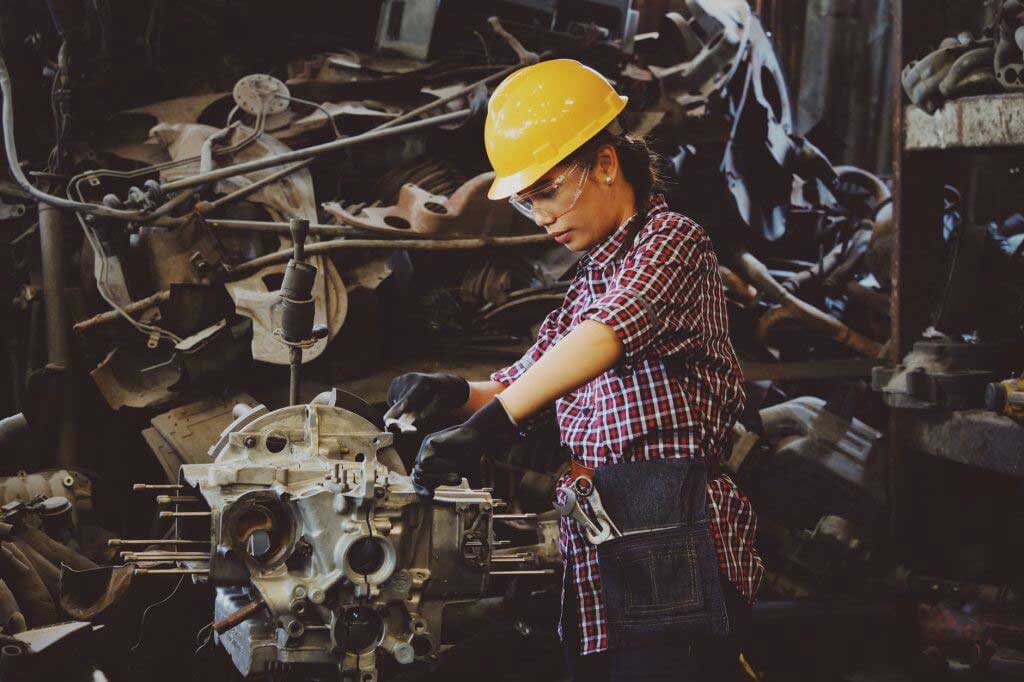 Factory worker using a machine around sheet metal