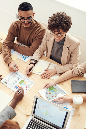 Colleagues discussing data printouts in a meeting