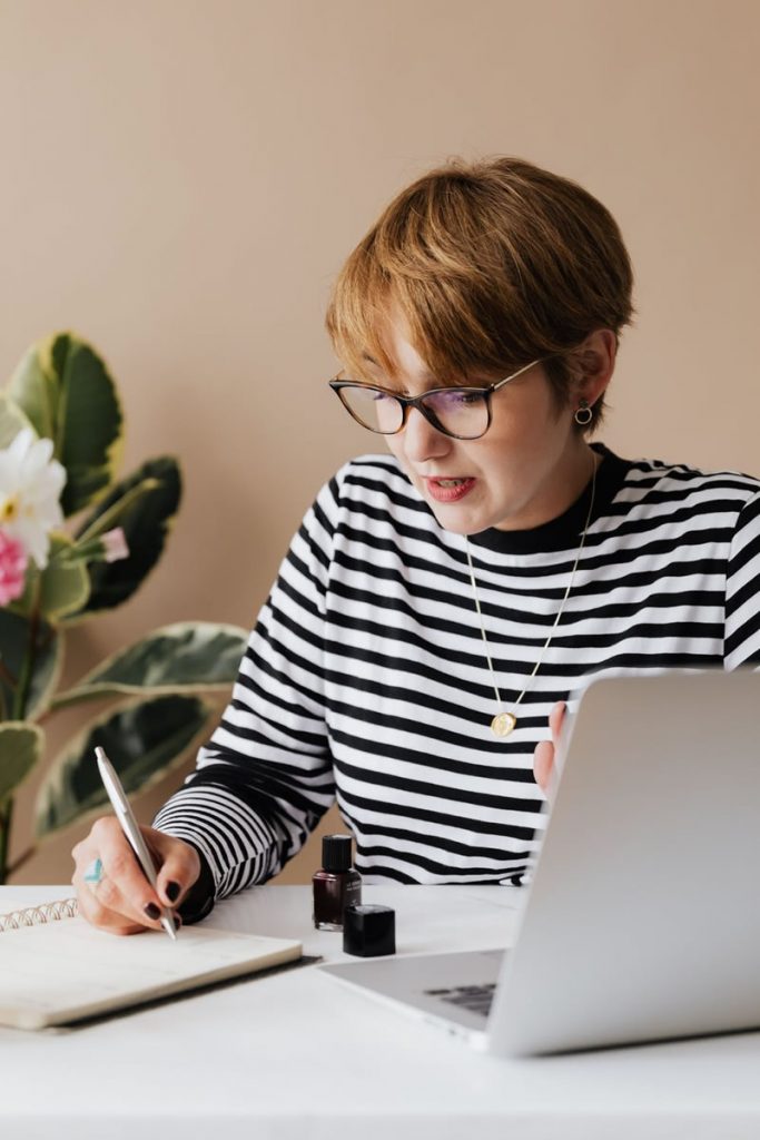 Woman taking notes with a laptop