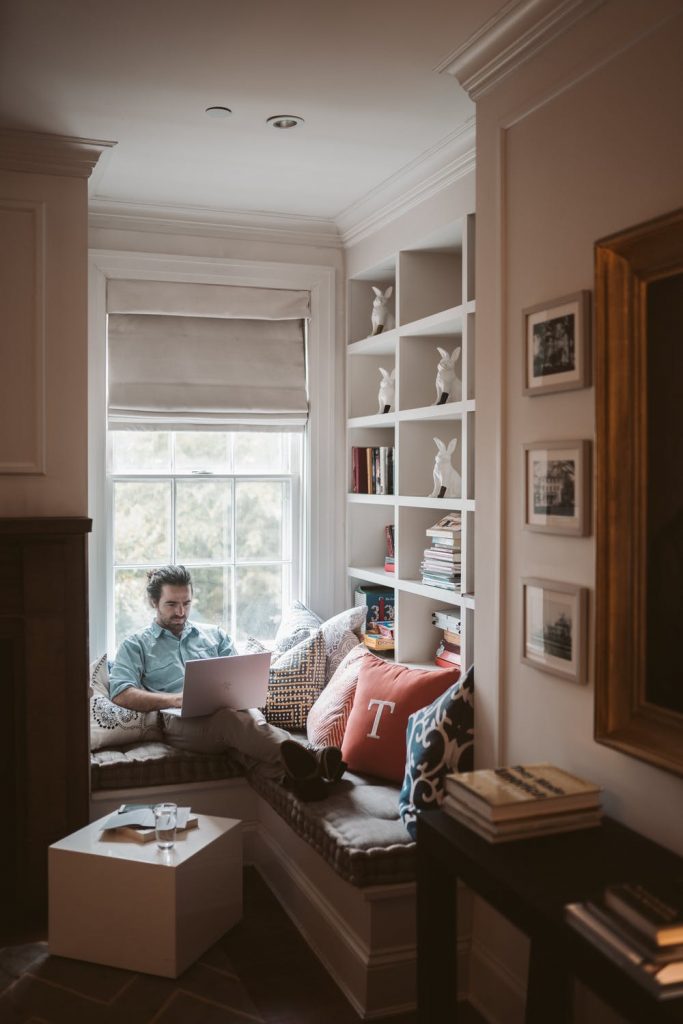 Man working from home near a window with his laptop