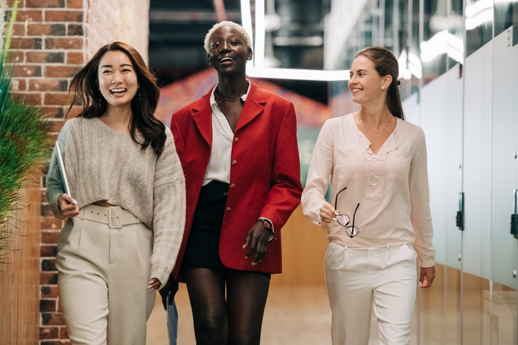 Three woman walking down a hallway