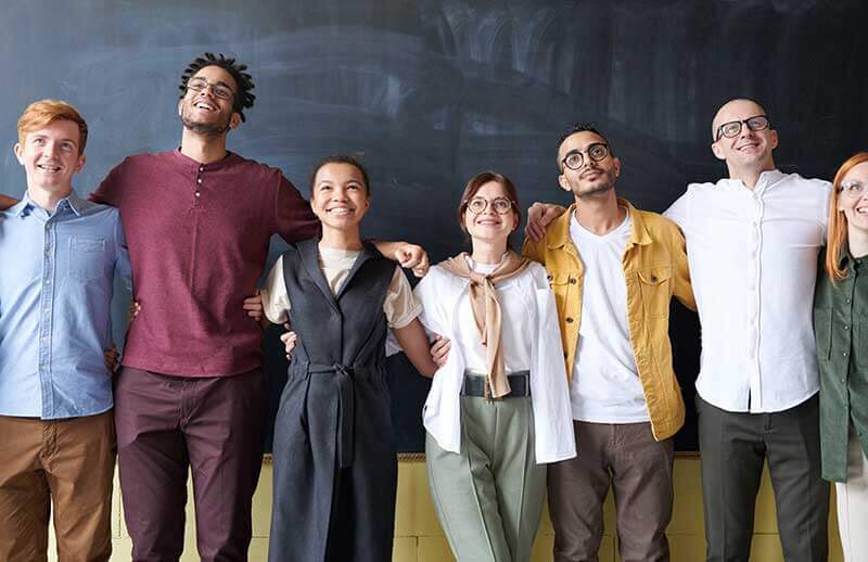 Colleagues posing in front of a classroom