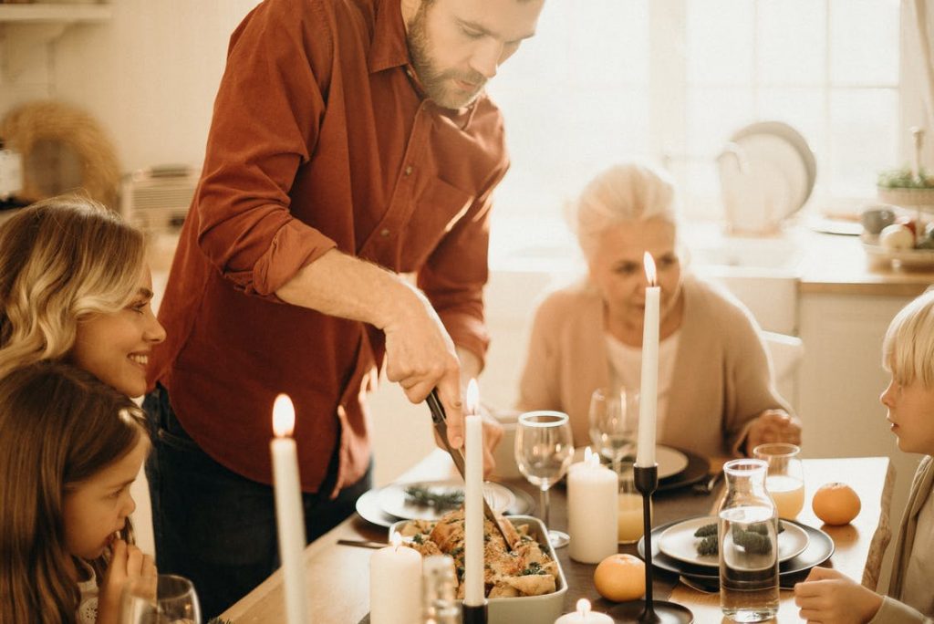 Man preparing chicken at a family dinner