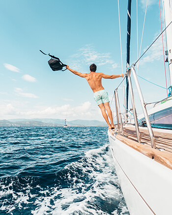 Man hanging off of a boat on the ocean