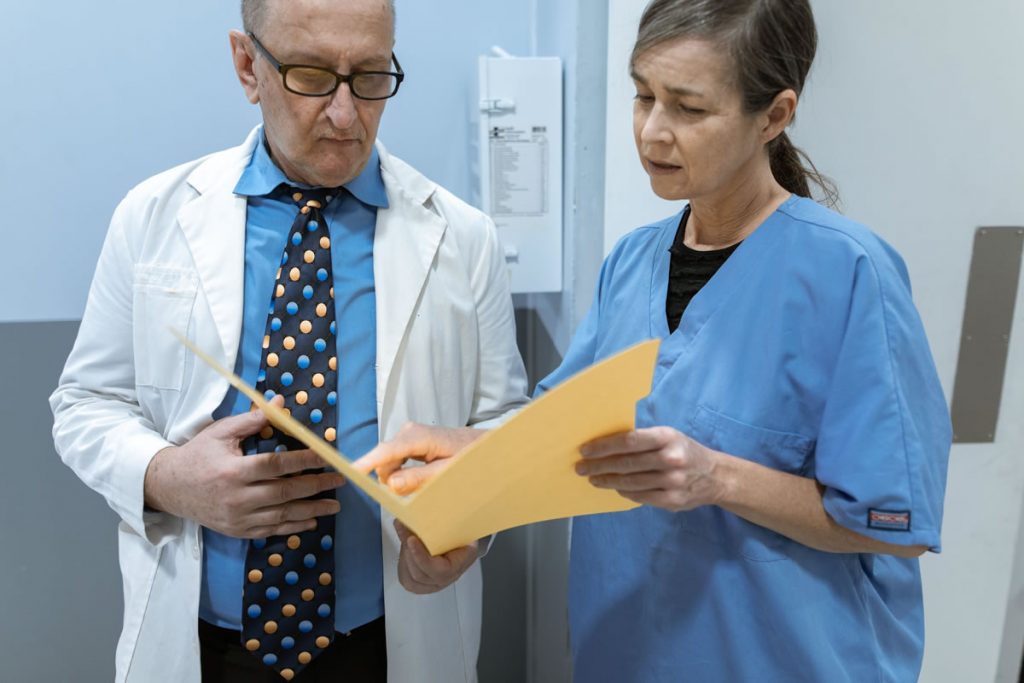 Two doctors having a discussion over a patients file