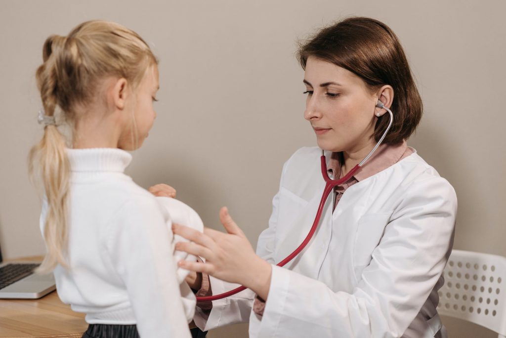 Doctor performing a checkup on a young girl with a stethoscope