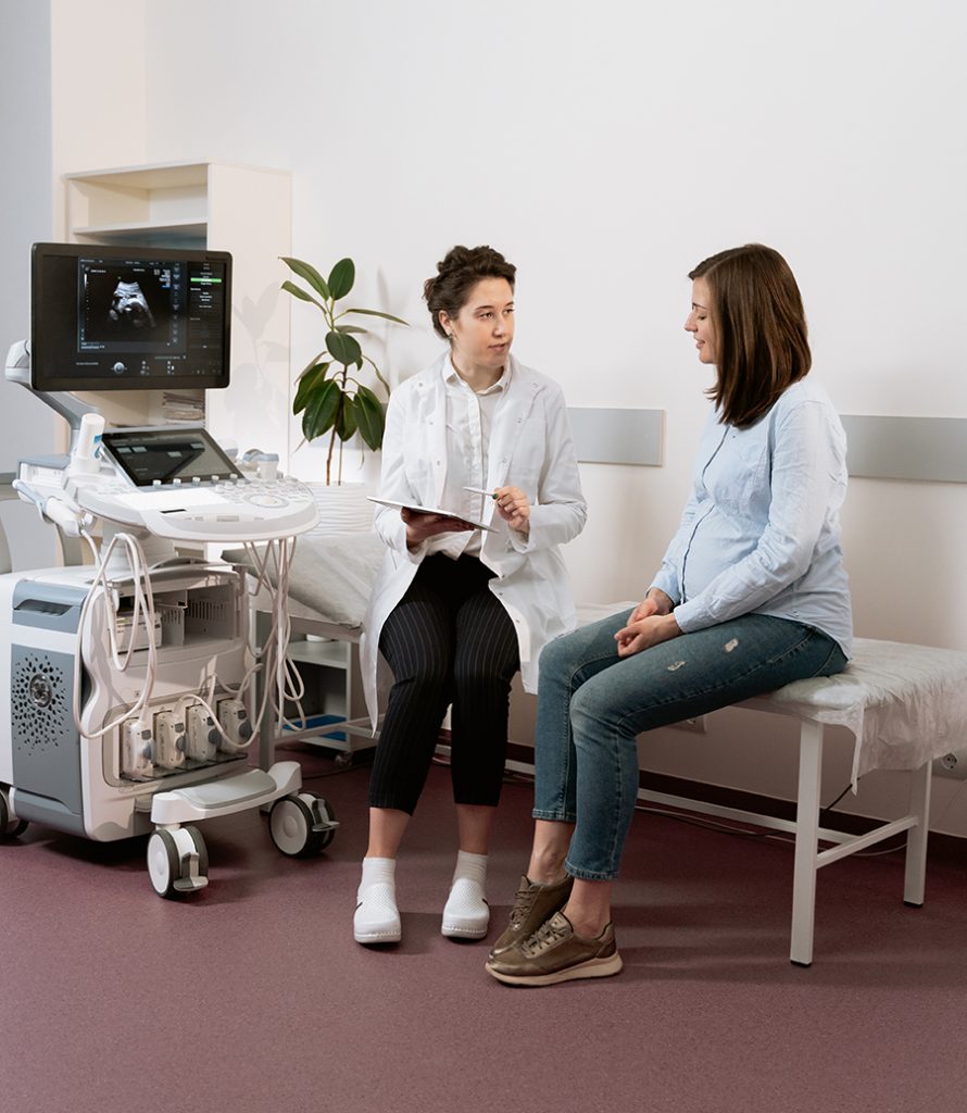 A doctor going over a sonogram with a pregnant patient in a hospital room