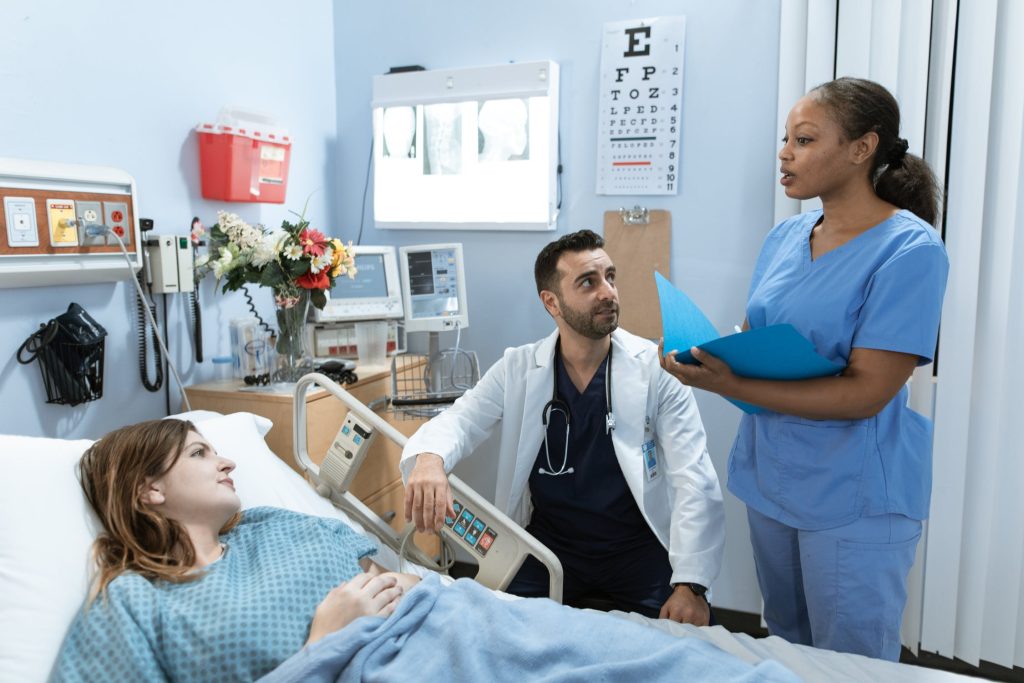 Doctors discussing options with a patient in a blue hospital room