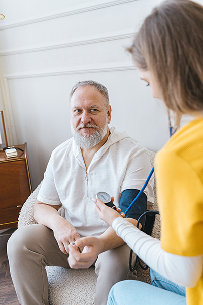 Woman using a stethoscope on an older patient in a doctors office