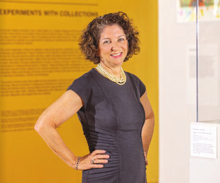 Ellen Dunkin stands in front of an orange and white background